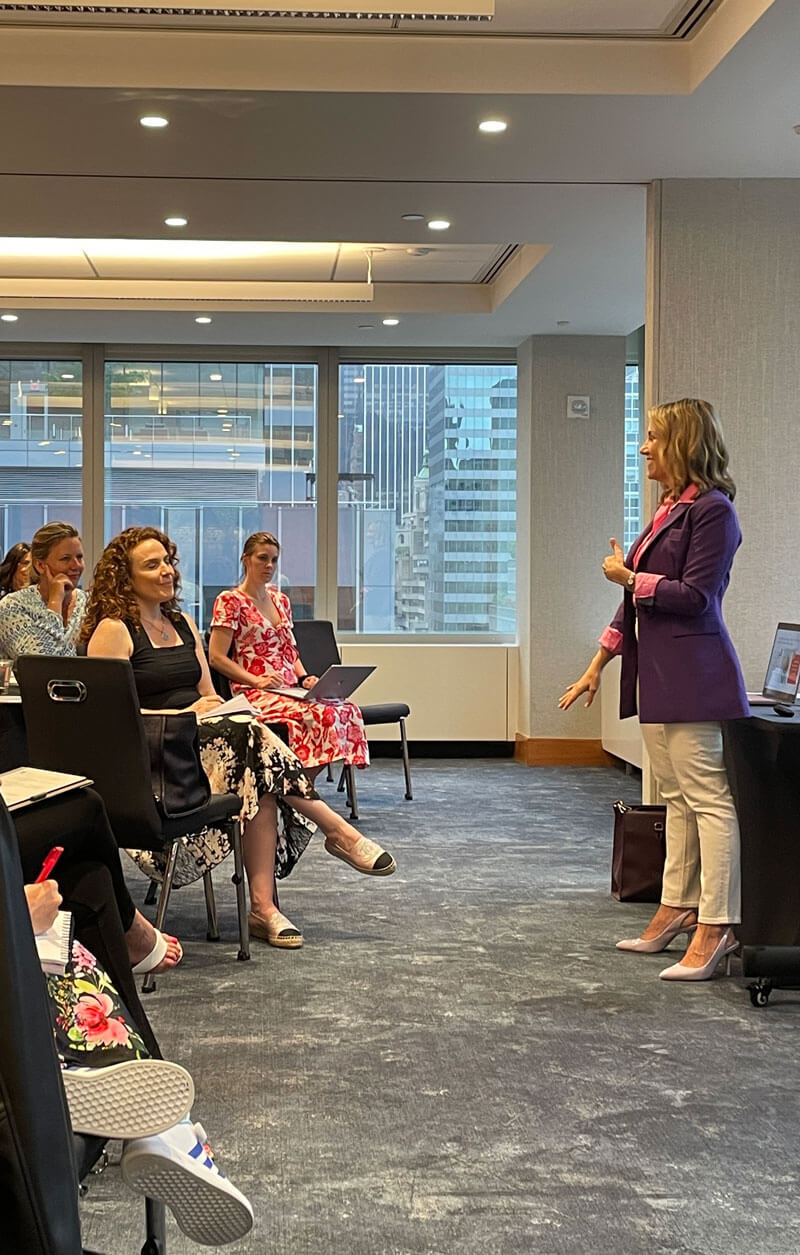 Elyssa Smith Elyssa speaking in front of a group of office workers