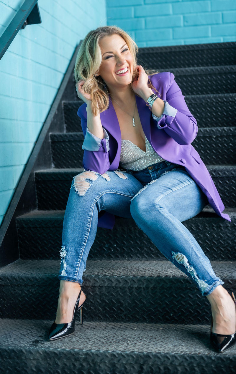 Elyssa Smith sitting in a stairwell laughing